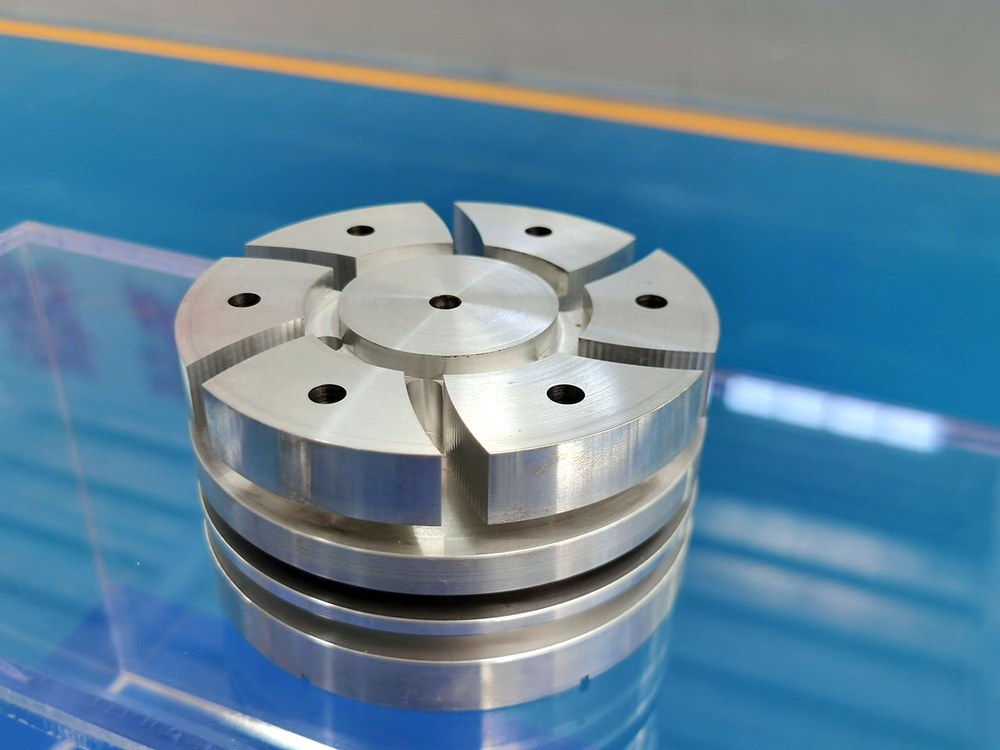 A turned machined shaft with threaded sections, polished shoulders, and a dark industrial finish